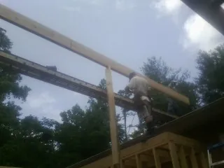 Carpenter setting a ridge beam over a new addition frame — Ice Dam Removal by Roofing Brothers in Winburne