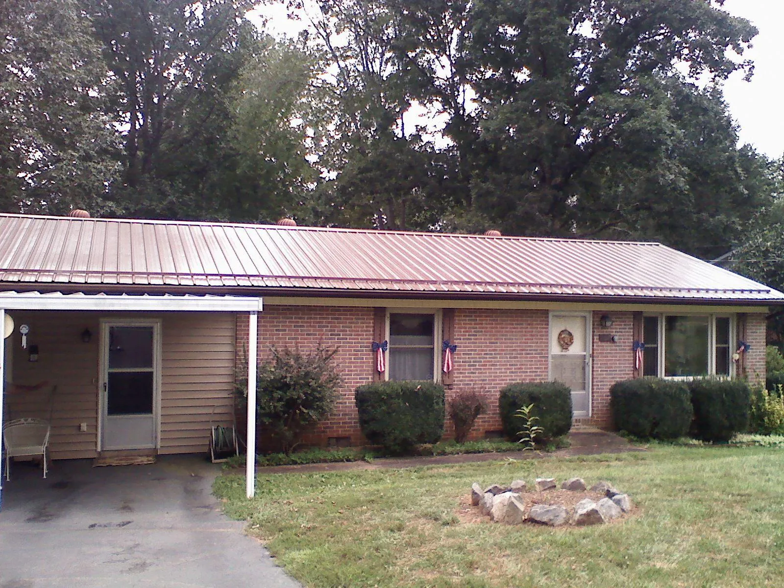 Bronze metal roof and carport on a brick ranch home — Roof Repair work by our crew in Winburne
